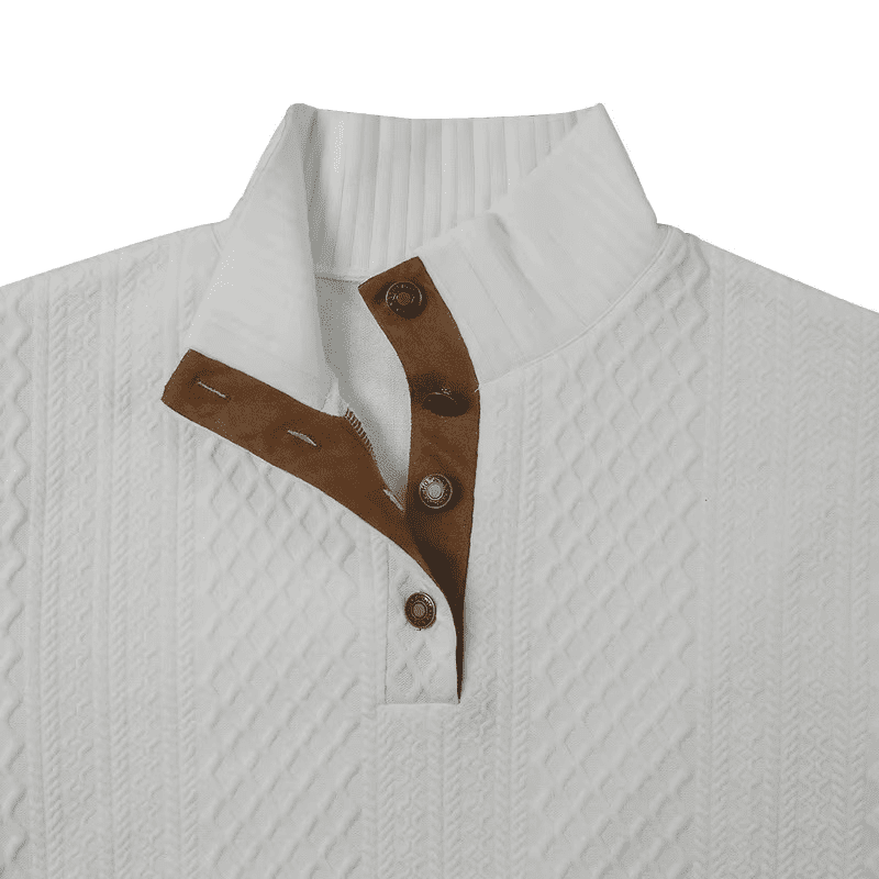 Homme assis sur un canapé portant le pull dans un cadre cosy.